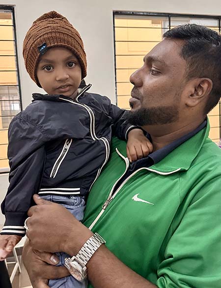 A father holds his son in a hospital