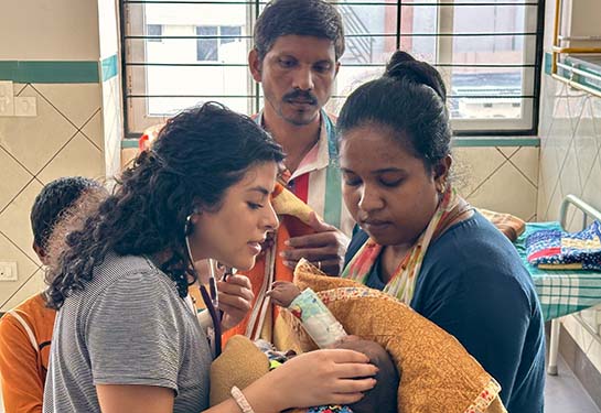 A physician treats a small child in its mother's arms