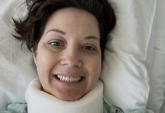 Woman in a padded neck brace in a hospital bed