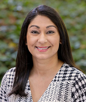 Person with black hair and houndstooth top.