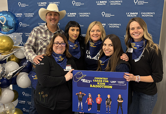 Group of people pose together with blue background