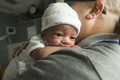 Man holds baby over shoulder