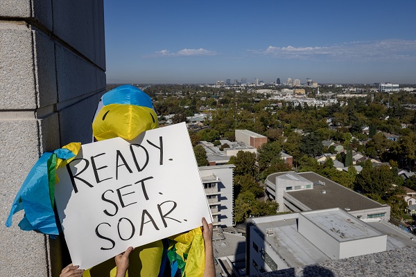 A falcon mascot displays a sign reading &ldquo;READY. SET. SOAR.&rdquo; above the UC Davis Health campus.