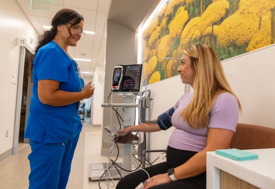A patient has blood pressure monitored during an appointment by a member of the care team.