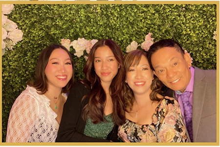 Four people in photo: From left to right, young Asian woman with shoulder length black hair, another young Asian woman with longer highlighted black hair; another Asian woman with shorter brown hair; and an Asian man with a purple short and tan blazer.