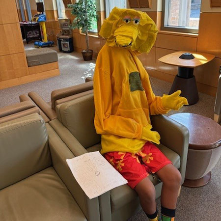 A boy in a big bird costume in a medical waiting room