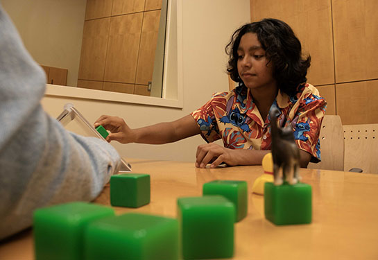 An adolescent research participant does a test involving blocks at the UC Davis MIND Institute