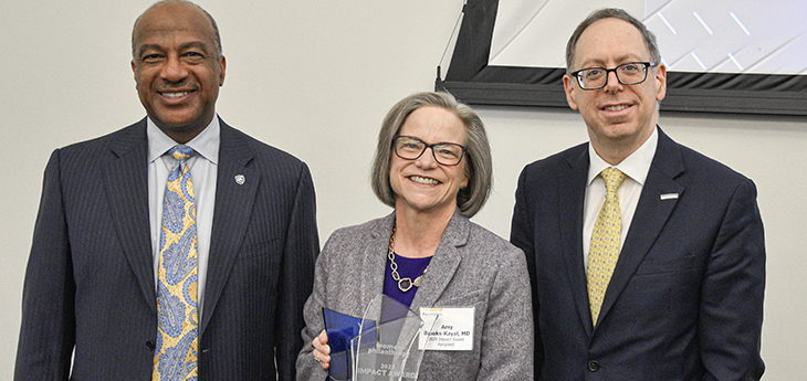Amy Brooks-Kayal poses for a photo with Chancellor Gary S. May and Vice Chancellor of Human Health Sciences Mark I. Rosenblatt.