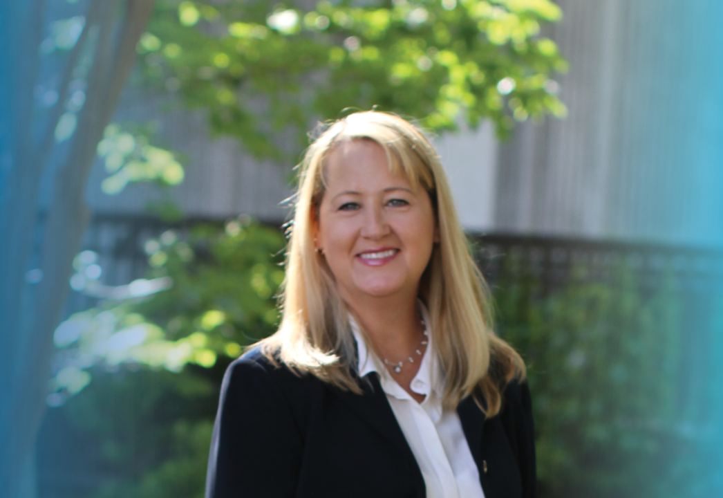 image of tammy kenber smiling in front of greenery