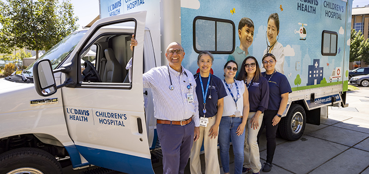 5 people stand in front of the van. 