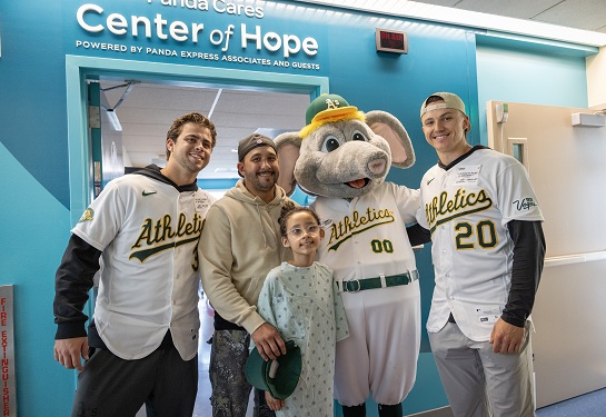 A's players and Stomper, the mascot, visit the Children's Hospital.