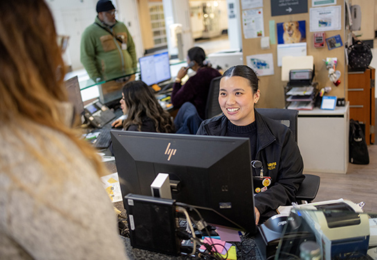 Woman at reception desk greets hospital guest