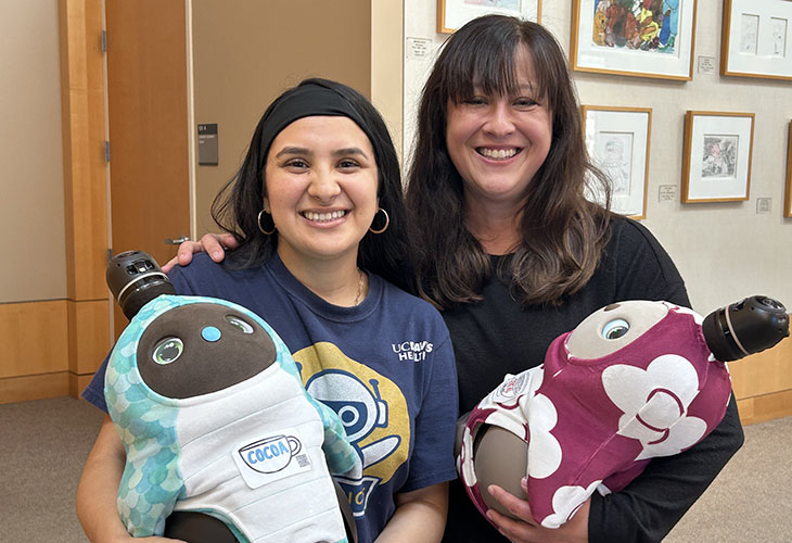 From left, Alondra Gonzalez and Veronica Ahumada each hold a LOVOT at the MIND Institute