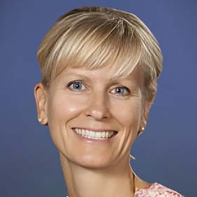 Professor Sarah Tomaszewski Farias, with her blonde hair pulled back, smiles for the camera.