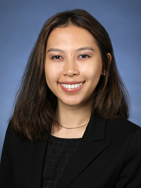 Portrait of Nhu Y “Thi” Doan against a blue background