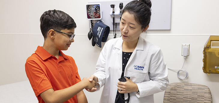  A physician shakes hands with a child.