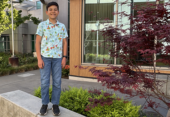 Smiling boy with black backpack on.