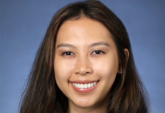 Portrait of Nhu Y “Thi” Doan against a blue background