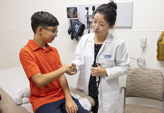  A physician shakes hands with a child.