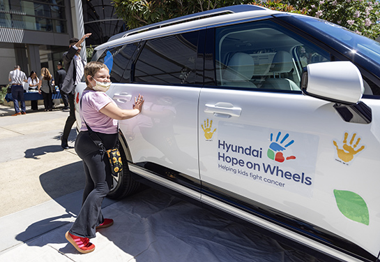 Alizah Martinez puts her painted hands on the white Hyundai Palisade