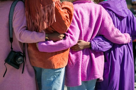 People wrapping their arms around one another in a group hug