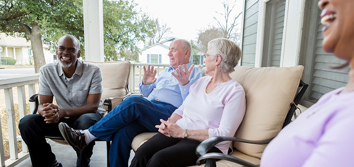 Four seniors sitting on the porch 