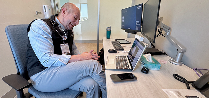 UC Davis Health telehealth Nephrologist José Morfín seated at a desk with a laptop during video appointment with patient