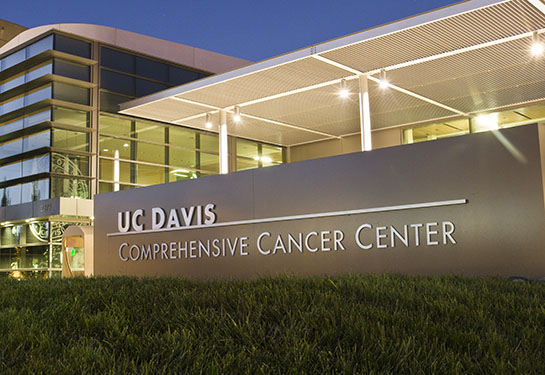 A night view of the steel and glass building of UC Davis Comprehensive Cancer Center. 