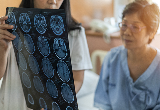 Clinician is showing a patient her MRI brain scans