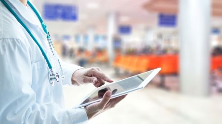 Medical professional holding an ipad.  