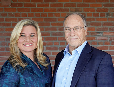 Professors Charles DeCarli (right) and Rachel Whitmer (left) are standing together and smiling to the camera.