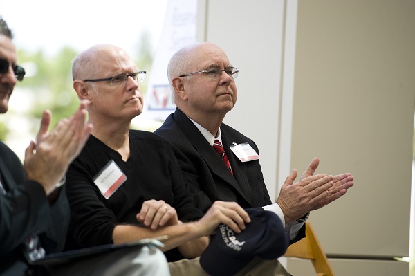 William McGowan sits among attendees during a UC Davis Health gathering and applauds during a presentation.