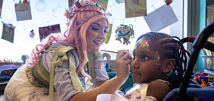 A person adds face paint to a child's face 