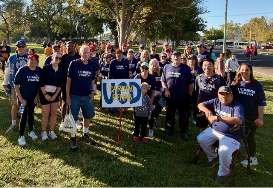 Members of the UC Davis Health Cardiac Rehabilitation Program with patients, staff and supporters beneath a “Cardiac Rehab” sign.