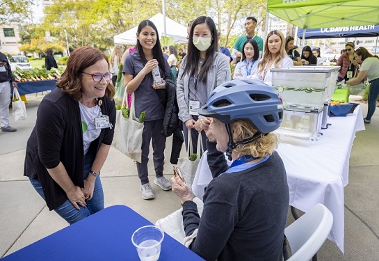Sarah Janus speaks with an employee wearing a bicycle helmet at a fitting event.