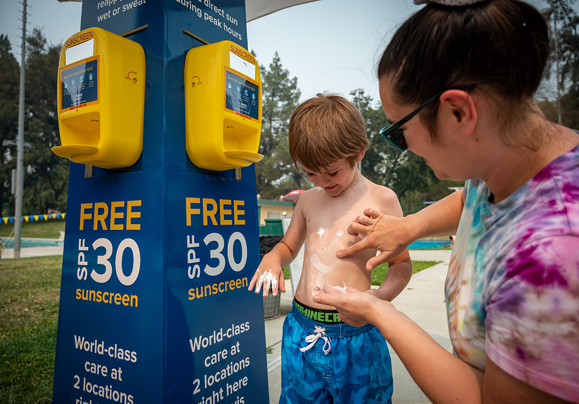 mom putting sunscreen on her young son