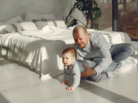 dad and son playing on a bedroom floor