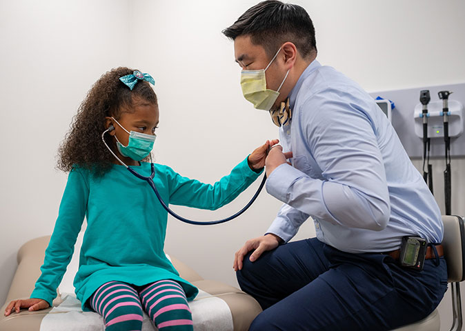 child listening to her pediatrician's heart