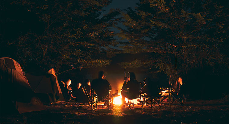 people gathered around a campfire at night and ways to treat burns
