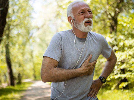 older man grasping at his chest, is it heartburn or heart attack?