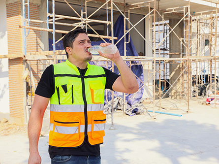 man with heat exhaustion wiping his head while working construction in the heat