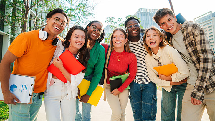 group of young adults smiling close to each other, interested in adolescent and young adult medicine