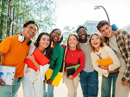 group of young adults smiling close to each other