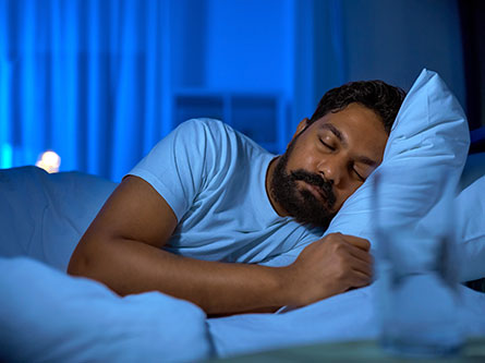 man sleeping in bed after taking melatonin and learning the side effects