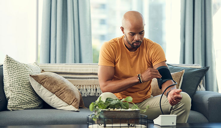 man with high blood pressure checking his numbers on a home monitor