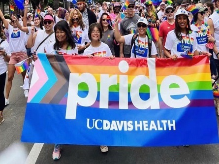 UC Davis Health employees holding PRIDE banner