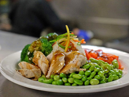 Plate of chicken with peas set out at cafeteria