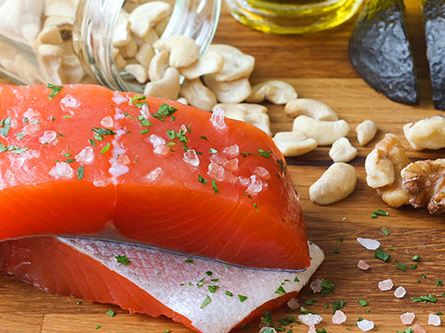 Raw salmon sitting on cutting board with garlic and walnuts