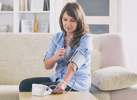 Woman checking blood pressure at home