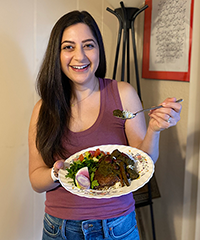 Golnaz holding a plate of Persian food